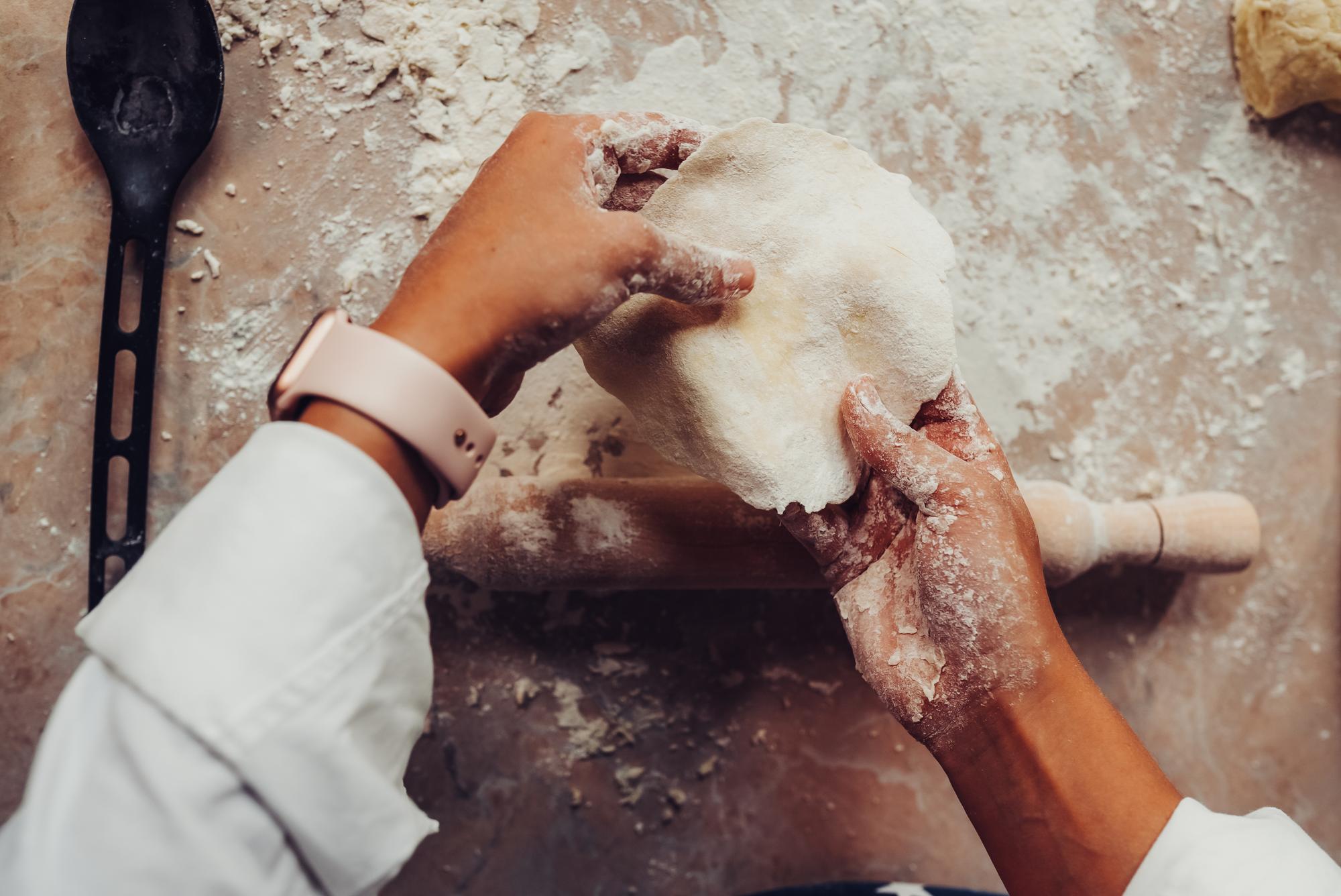 Hands shaping dough in workshop